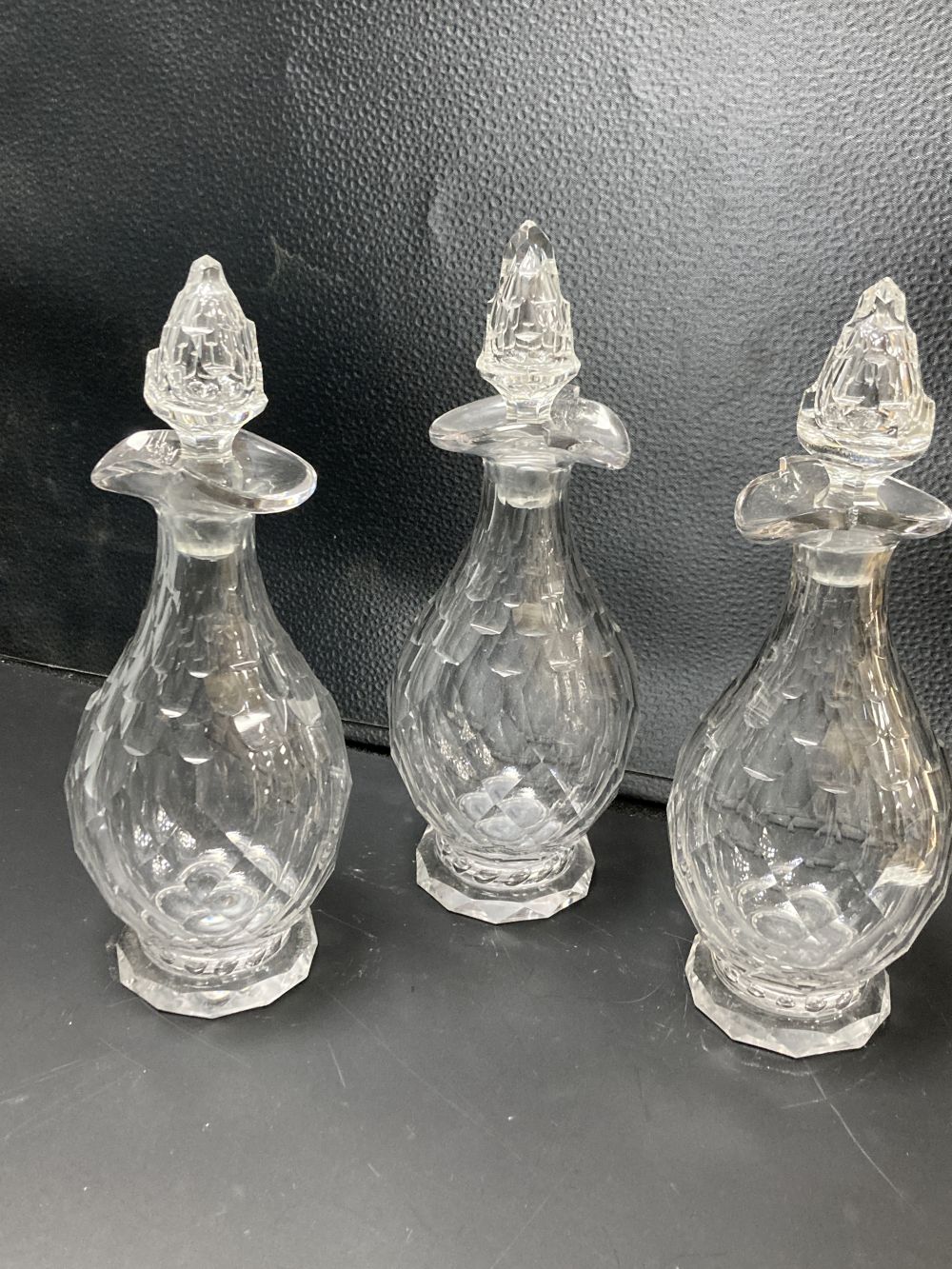 A set of three facet cut glass decanters and stoppers, early 19th century, 27.5cm